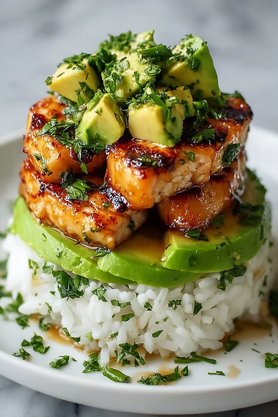 This image shows a three-layer food stack on a white plate with a few green herbs sprinkled around. The bottom layer is a mound of fluffy white rice with some parsley bits. On top of the rice is a thick, smooth, bright green layer of sliced avocado. Above the avocado, there are several golden-brown grilled pieces with a slightly shiny and sticky look, topped with small green herb pieces. On the top, there are several chunks of fresh green avocado with finely chopped herbs on them. The whole dish is on a white marbled surface. Photo taken with an iphone --ar 2:3 --v 7 - Honey Lime Chicken Rice Stack, Honey Lime Chicken, Chicken rice bowl, Easy weeknight dinner, Healthy rice recipes