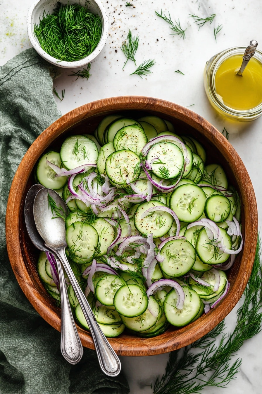 A wooden bowl filled with three layers: the bottom is several thin, round slices of bright green cucumber with visible darker green skins, the second layer has thin curved rings of pale purple-red onion, and the top layer is scattered fresh sprigs of bright green dill, lightly sprinkled with coarse black pepper. Two silver spoons rest inside the bowl on the left side. Above the bowl, there is a small white bowl filled with more fresh dill and a glass jar of light yellow dressing with a silver spoon inside. The bowl and items are set on a white marbled surface with some dill sprigs scattered around and a folded green cloth on the bottom left corner. photo taken with an iphone --ar 2:3 --v 7 - Cucumber Red Onion Salad with Lemon Dill, cucumber onion salad, lemon dill dressing recipe, healthy cucumber salad, easy summer side dish