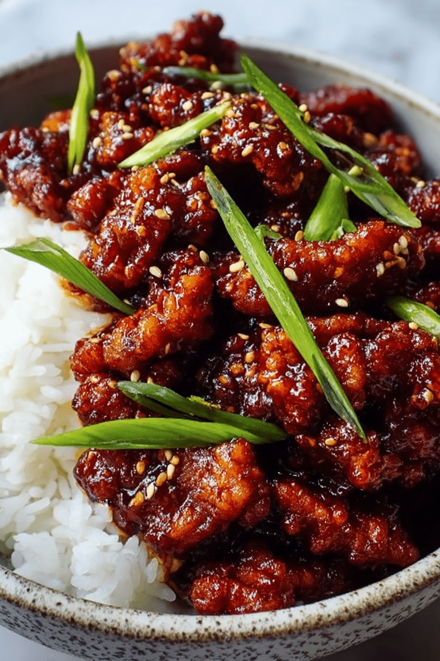 A black bowl filled with two main layers: the bottom layer is white sticky rice with a soft, grainy texture, while the top layer has many small, crispy pieces of fried food coated in a shiny dark reddish-brown sauce. Scattered on top are bright green sliced green onions that add a fresh, crisp look. The bowl sits on a white marbled surface. Photo taken with an iphone --ar 2:3 --v 7 - Spicy Dragon Chicken, crispy spicy chicken, Asian fried chicken, quick spicy chicken recipe, flavorful chicken dinner